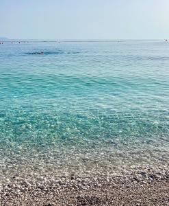 a beach with clear blue water and a rocky shore at Chalet Ambel in Dhërmi