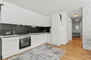 une cuisine blanche avec des armoires blanches et un tapis dans l'établissement Modern Apartment I Parking I Vienna, à Vienne