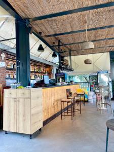 a restaurant with a bar with chairs and tables at Chalet Ambel in Dhërmi