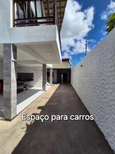 a building with a white wall and a sidewalk at Casa na praia com vista para o mar in Luis Correia