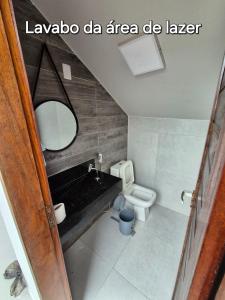 a bathroom with a toilet and a sink and a mirror at Casa na praia com vista para o mar in Luis Correia