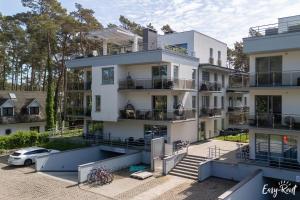 an apartment building with a car parked in front of it at Apartament typu studio Doris 3 - 50m od plaży in Pobierowo