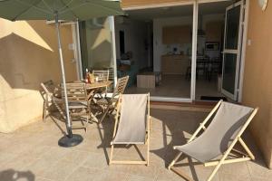 a patio with a table and chairs and an umbrella at APPA106 - Apartment F2 - 4 pers - Sea view - air conditioning - Swimming po in Serra-di-Ferro