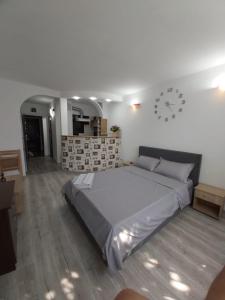 a bedroom with a large bed and a clock on the wall at Garsoniera tiglina1 in Galaţi +9 photos