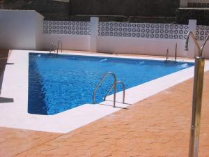 a swimming pool with blue water in a building at BALCON PLAYA Y PISCINA Velimar PONDOS in Almuñécar