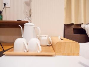 a tea kettle and two cups on a wooden tray at ELE HOTEL Higashi Ueno - Vacation STAY 08002v in Tokyo
