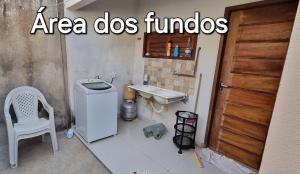 a small bathroom with a sink and a refrigerator at Casa na praia com vista para o mar in Luis Correia +15 photos