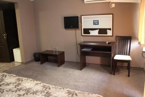a hotel room with a desk and a bed at Guest House Lazur in Burgas