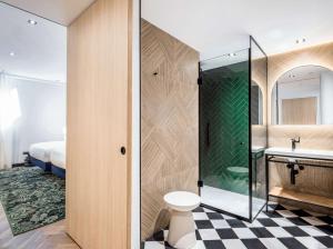 a bathroom with a shower and a toilet and a sink at Doubletree By Hilton Nice Centre Iconic in Nice