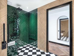 a bathroom with a shower with a checkered floor at Doubletree By Hilton Nice Centre Iconic in Nice
