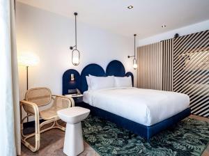 a hotel room with a bed and a chair at Doubletree By Hilton Nice Centre Iconic in Nice