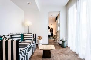 a living room with a couch and a table at Doubletree By Hilton Nice Centre Iconic in Nice