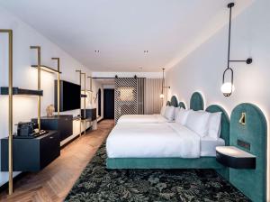 a hotel room with a bed and a flat screen tv at Doubletree By Hilton Nice Centre Iconic in Nice