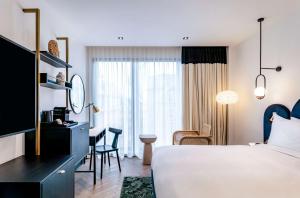 a hotel room with a bed and a desk at Doubletree By Hilton Nice Centre Iconic in Nice
