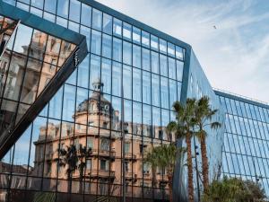 an old building reflected in the glass of a building at Doubletree By Hilton Nice Centre Iconic in Nice