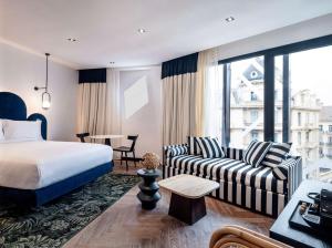 a hotel room with a bed and a couch at Doubletree By Hilton Nice Centre Iconic in Nice