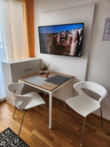ミュンヘンにあるMyRoom - Munich Fair Apartmentsのテーブルと椅子2脚のあるダイニングルーム