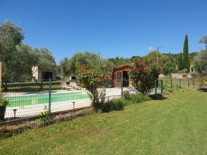 a tennis court in a yard with a fence at Gîte et piscine l'écrin aux oliviers en Cévennes in Saint-Christol-lès-Alès