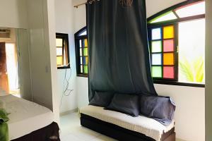 Una habitación con una cama con cortina y dos ventanas. en Apart recreio dos bandeirantes, en Río de Janeiro