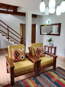 un soggiorno con due sedie e uno specchio di Hermosa Villa La Laja Rionegro a Rionegro