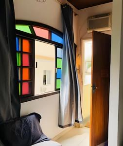 Una habitación con una vidriera y una cama. en Apart recreio dos bandeirantes, en Río de Janeiro