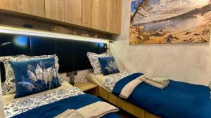 a bedroom with two beds and a painting on the wall at Sunset Coast - Paradise Cottage in Drage