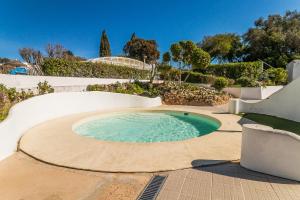 ein runder Pool auf einer Terrasse mit Bäumen und Sträuchern in der Unterkunft Marrocha II in Lagoa