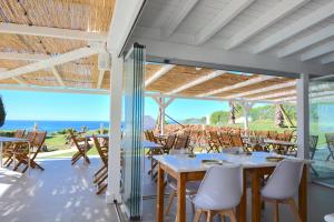 ein Esszimmer mit Tischen, Stühlen und Meerblick in der Unterkunft Marrocha II in Lagoa
