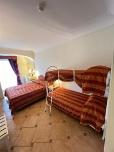 a bedroom with two beds and a table at Hotel La Vue d'Or in Sorrento