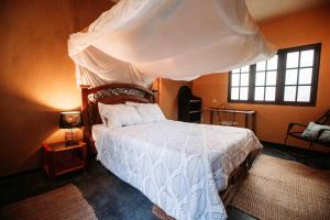 a bedroom with a bed with a canopy at AguaMar Vichayito in Vichayito