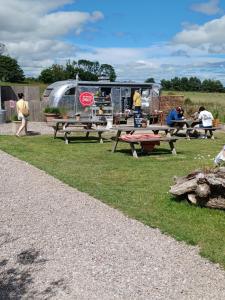 a group of people standing around a picnic table and a trailer at The Boathouse in Ballycotton