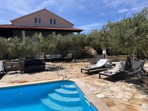 a swimming pool in front of a house at Villa Belvedere Žiža in Donji Humac