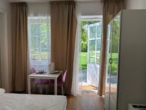 a bedroom with a table and a room with a window at Apartment mit Gartenblick und Terrasse in Baden