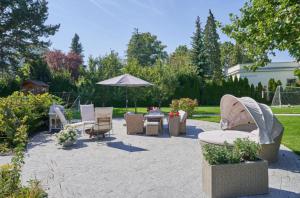 a patio with chairs and a table and an umbrella at Apartment mit Gartenblick und Terrasse in Baden +10 photos
