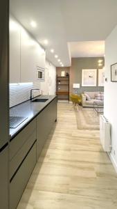 a kitchen with white cabinets and a living room at Eduardo Lucena Córdoba Center in Córdoba