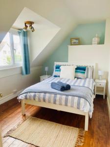 a bedroom with a bed with blue and white sheets at Lovely big 3 bedroom maisonette close to the beach in Llandudno