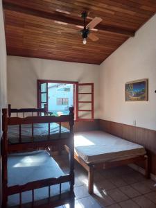 a room with three bunk beds and a ceiling fan at Chalés Luz Da Lua in Caraguatatuba