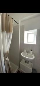 Un baño con lavabo y cortina de ducha. en Civico 12, en Ischia di Castro 8 fotos más