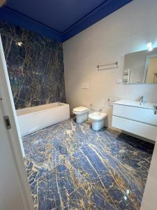 a bathroom with two toilets and a tub and a sink at Villa Diana in Montecatini Terme +24 photos