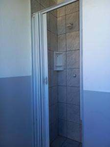 a bathroom with a shower with a glass door at Chalés Luz Da Lua in Caraguatatuba +29 photos