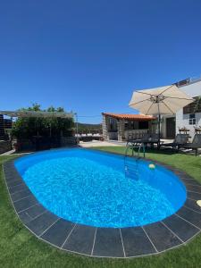 duży niebieski basen z parasolem w obiekcie Casa Christina-Luxury Villa w mieście Kisamos