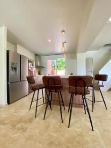 ルオムにあるMaison pour 12p, piscine à débordement chauffée d'avril à octobre inclusのキッチン(テーブル、茶色の椅子付)