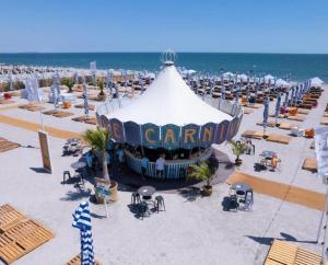 a circus tent on the beach next to the ocean at Summerland Nikos Residence in Mamaia