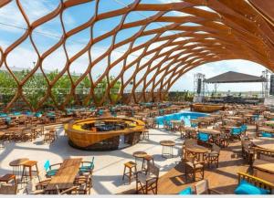 a rendering of a restaurant with tables and chairs at Summerland Nikos Residence in Mamaia