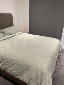 a bed with a white comforter in a bedroom at Royal One Bed Apartment in North Woolwich