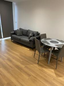 a living room with a couch and a table and chairs at Royal One Bed Apartment in North Woolwich