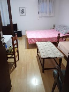 a room with two beds and a table and chairs at Apartments Sino More in Tivat