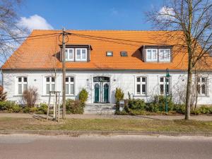 a large white house with an orange roof at Ferienwohnung in Buchholz an der Müritz in Buchholz
