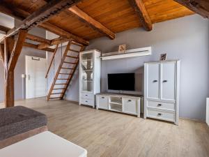 a living room with a television and a staircase at Studio in Buchholz am Müritzsee in Buchholz