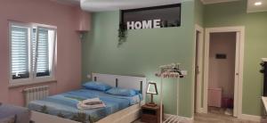 a bedroom with a bed with a home sign on the wall at Home trani in Trani